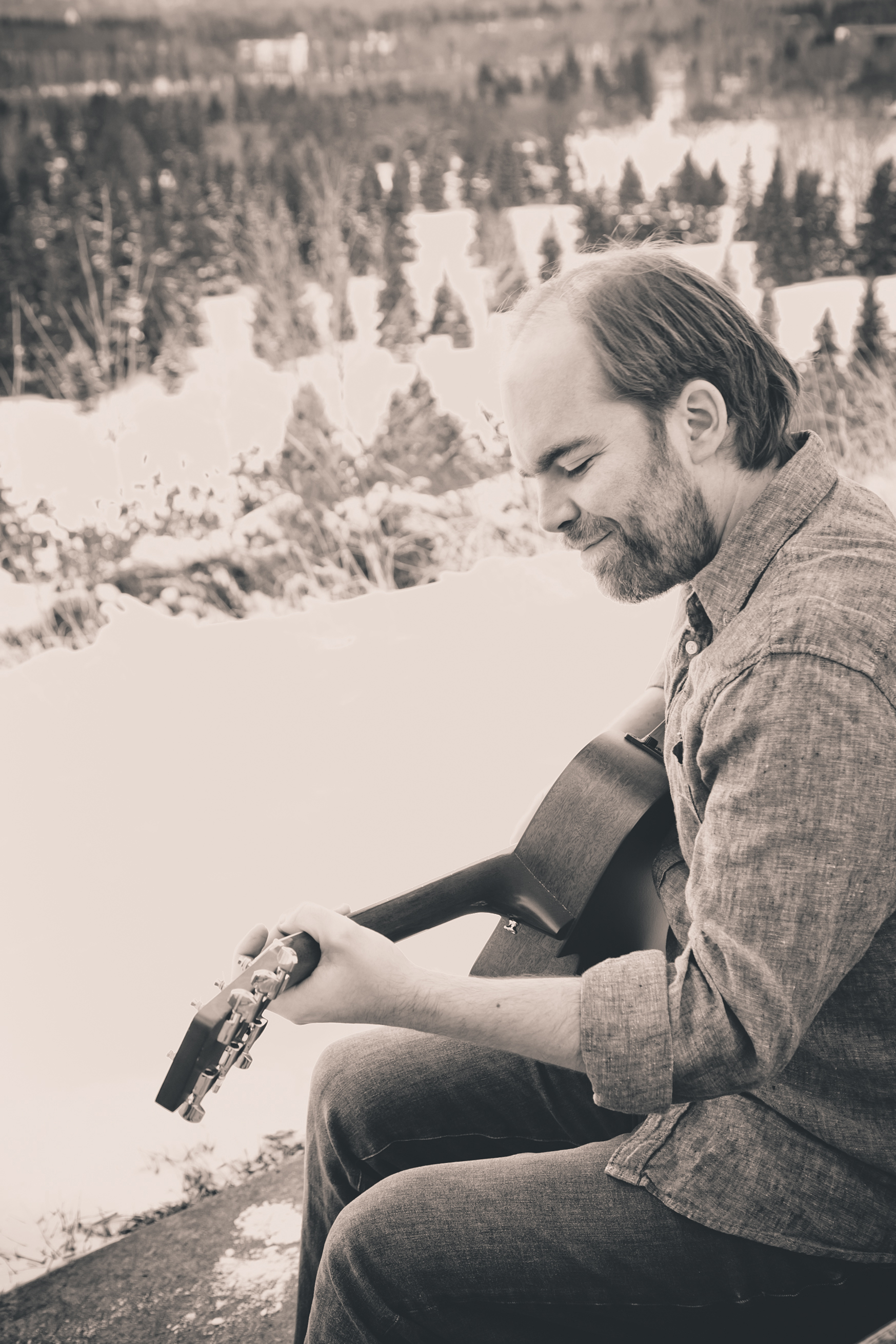 Douglas Mitchell playing guitar in Edmonton's winter river valley